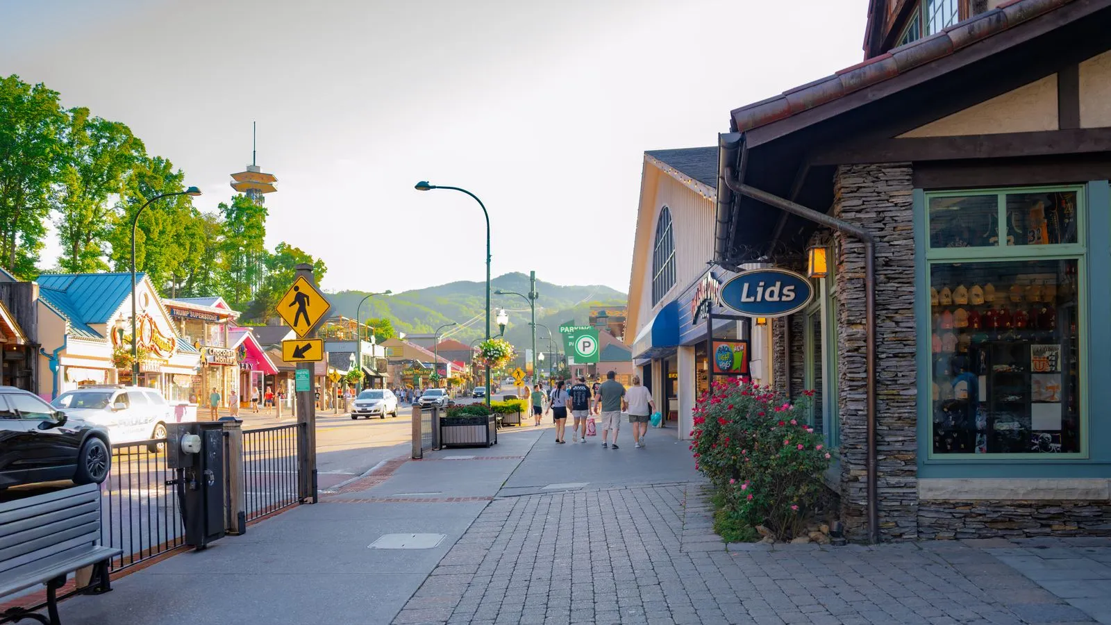 A small-town American Main Street lined with storefronts, with mountains in the distance