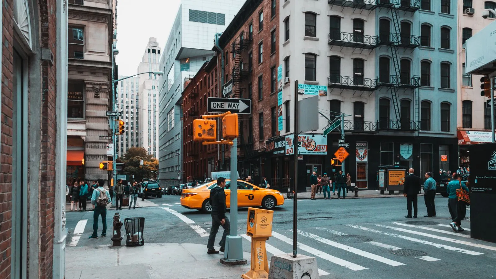 A busy city intersection with many pedestrians crossing the street